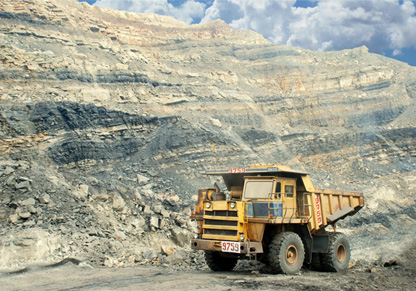 A cargo carrying truck in front of a rocky landscape