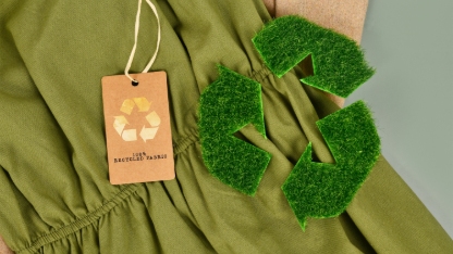 Green and beige eco friendly cotton fabric with 100 percent recycled label and recycling symbol made out of grass